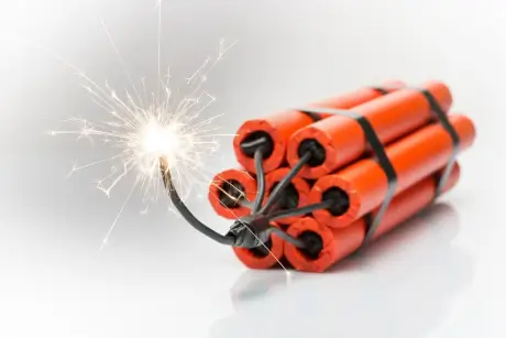 Ein Bündel orangefarbener Feuerwerkskörper mit sprühender Zündschnur als stimmungsvolles Motiv für eine Partyveranstaltung.