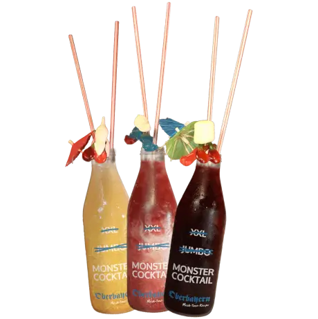 Drei Monster Cocktails in Flaschen, dekoriert mit Strohhalmen und Mini-Schirmchen, auf der Terrasse des Oberbayern Düsseldorf.