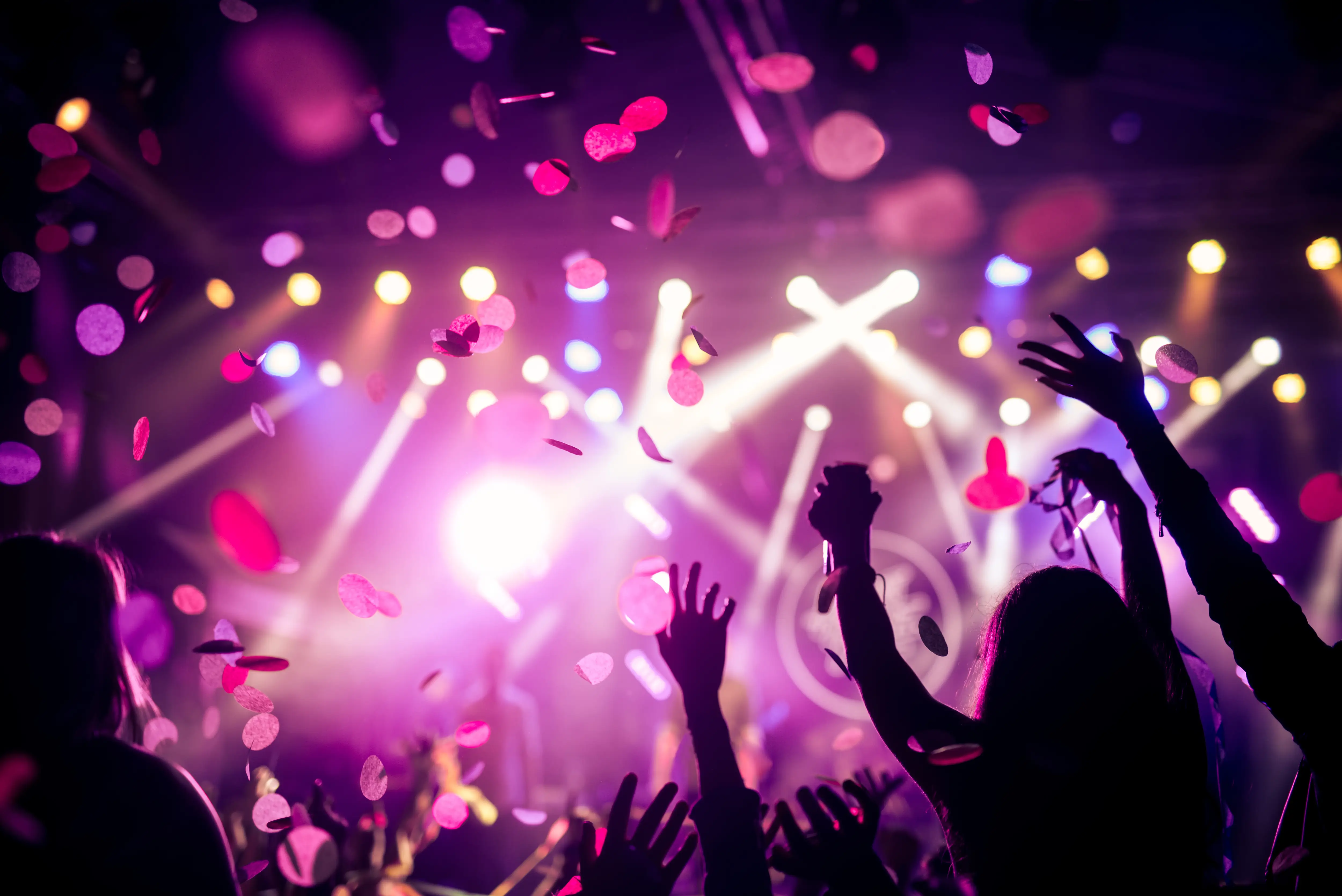 Bunte Partylichter und tanzende Silhouetten als stimmungsvolles Motiv für Partyevents.